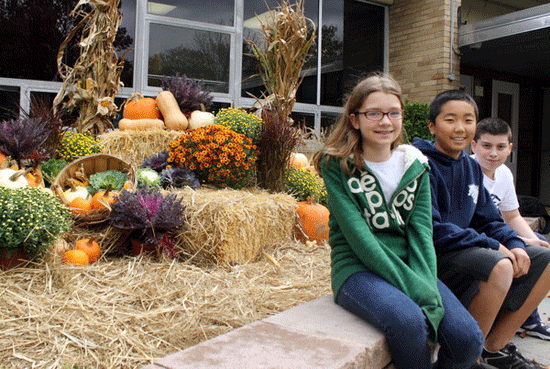 Students Emily McCausland, Kohei Ito and Anthony Ferraioli in front of decorations at West Brook Middle School donated by landscaper Dennis Ferraioli on Oct. 20, 2011. Dennis Ferraoili is Anthony's uncle.